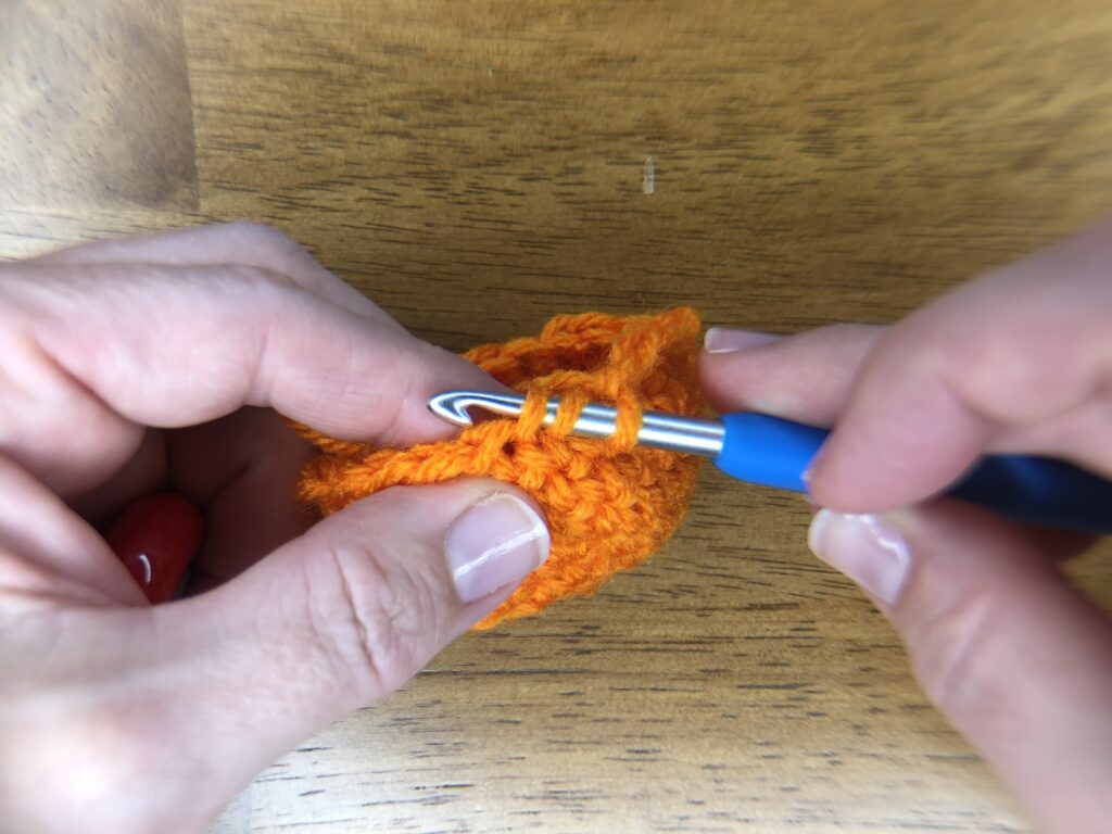 step 2 of an invisible decrease in crochet to make baby pumpkins