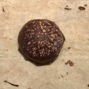 Single tiramisu chocolate covered cake ball dusted with cocoa powder