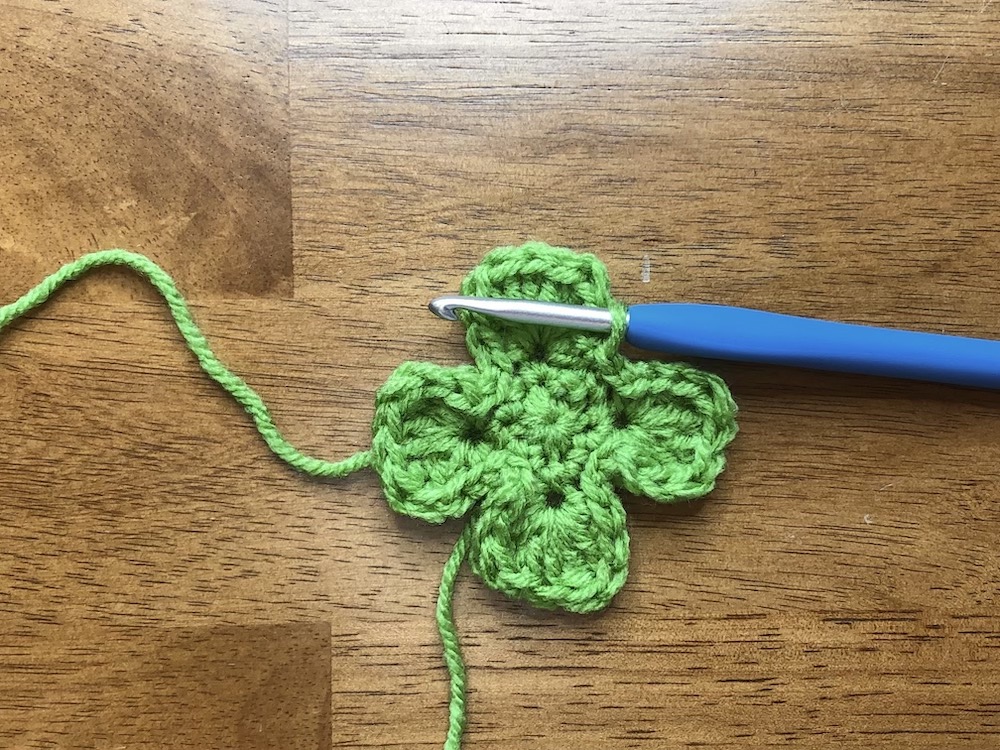 small green crocheted shamrock without stem
