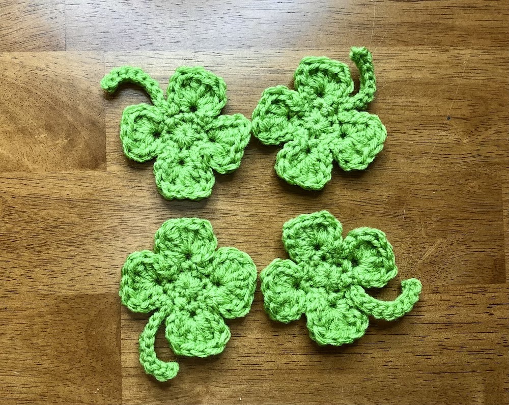 4 small green crocheted shamrocks