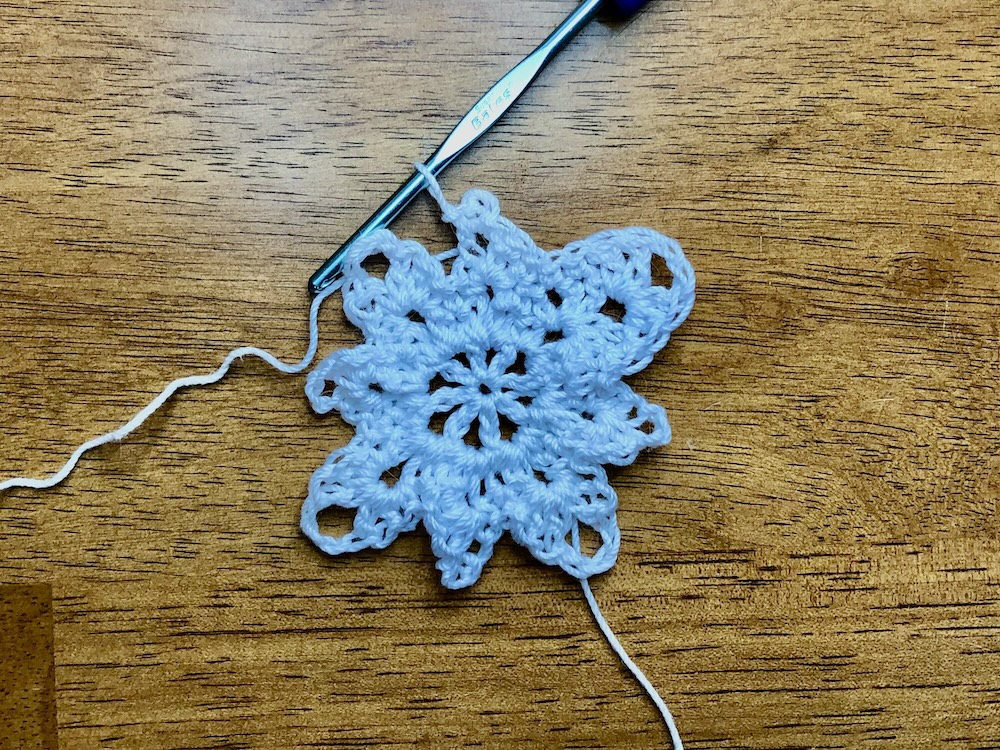 white Christmas star ornament showing completed second chain 3 space in round 4