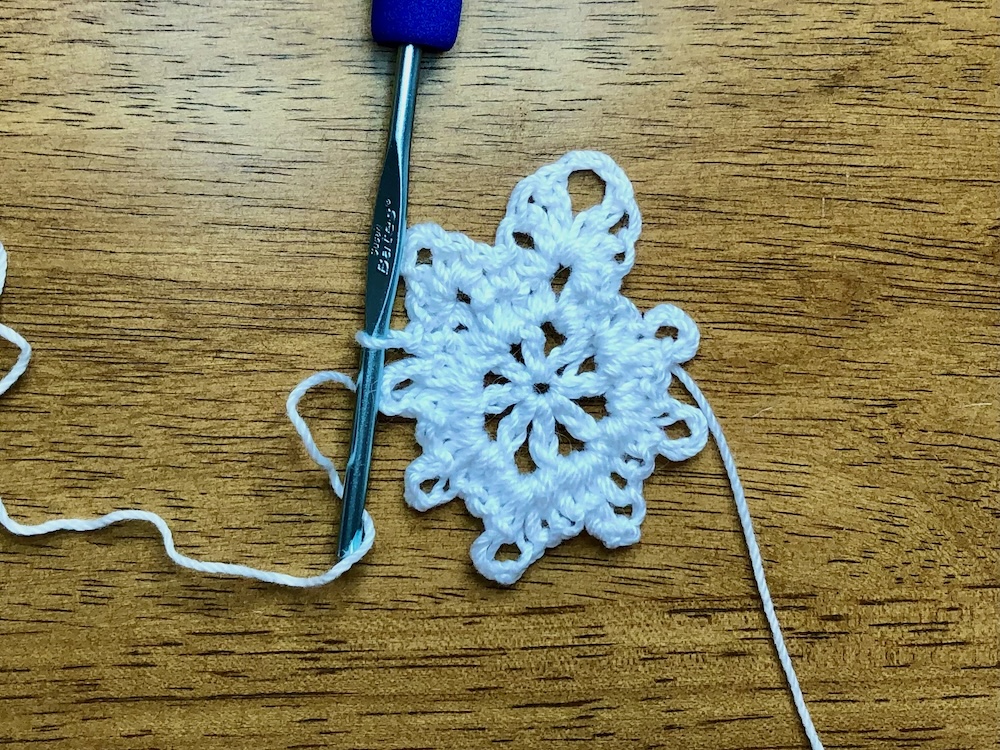 white christmas star ornament showing the stitch combination in the second chain 3 space in the 3rd round. 