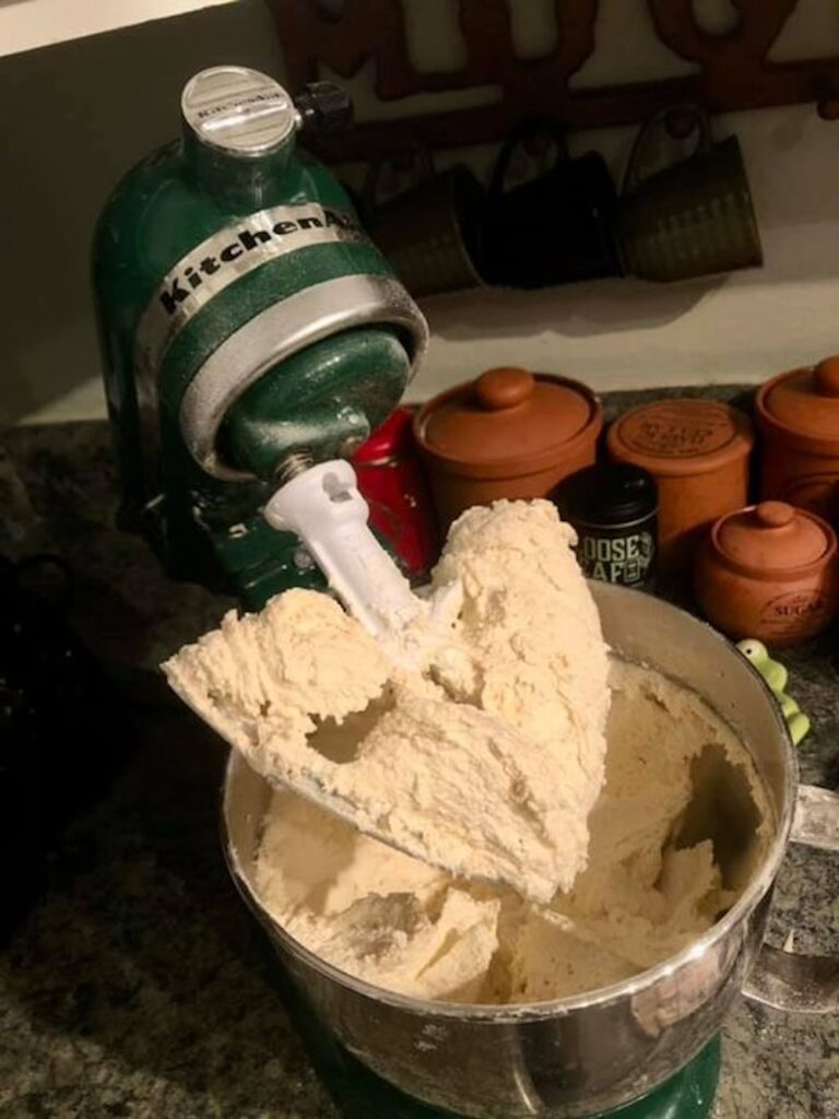 green kitchenmaid stand mixer with cookie dough in the bowl and on the beater