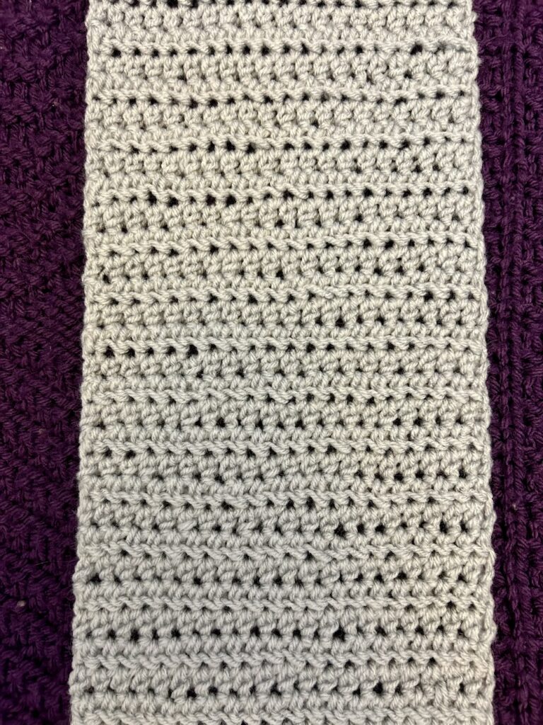 close up of light gray crochet scarf for charity worked in half double crochet stitches