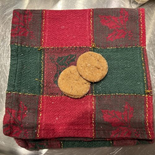 small, round molasses spice cookies on a red and green napkin