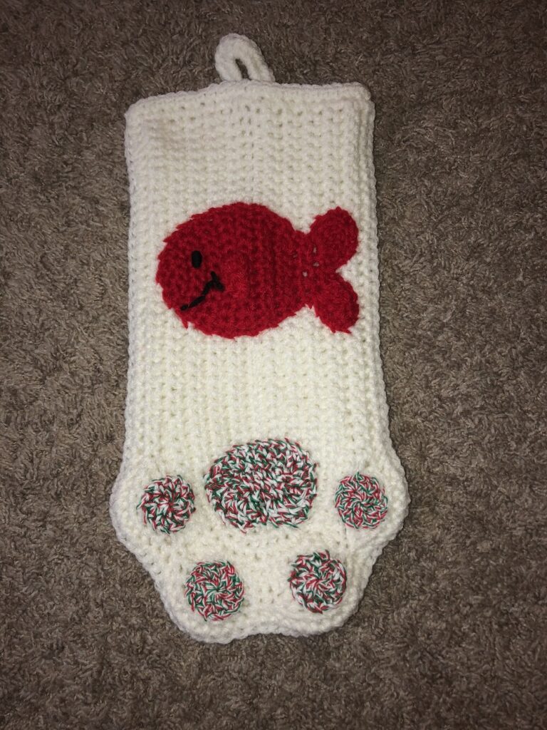 white stocking with a cat paw design and a fish applique