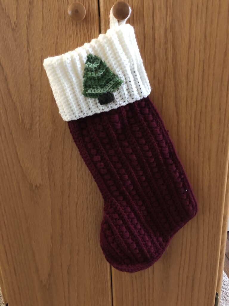 burgundy stocking with white cuff and a Christmas Tree applique