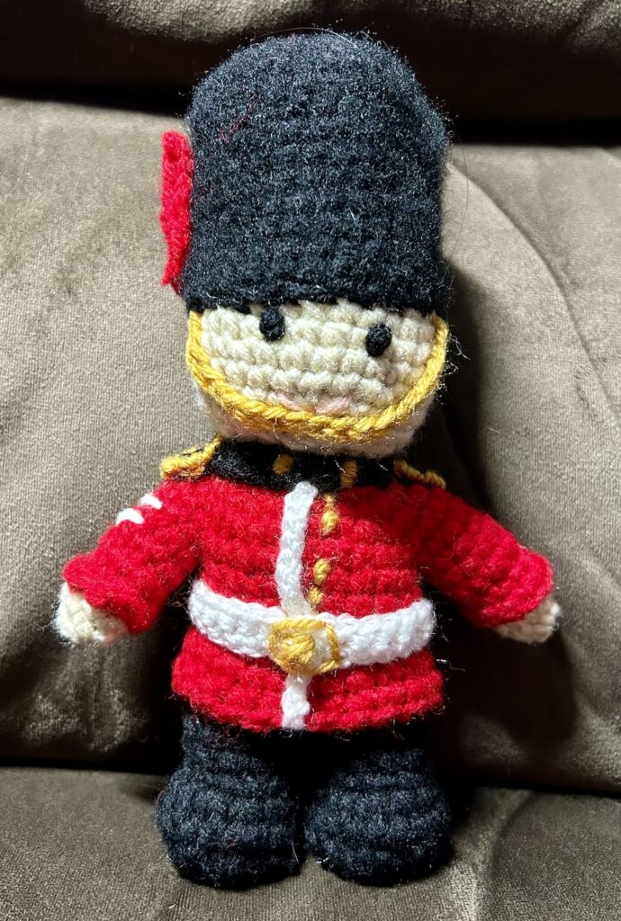 crochet Cold Stream Guardsman with red tunic, white belt and bearskin hat.
