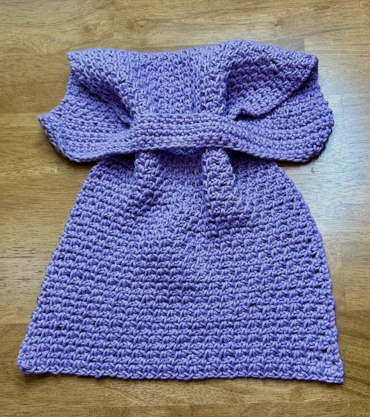 purple crocheted hand towel with stay put loop on a wood background.